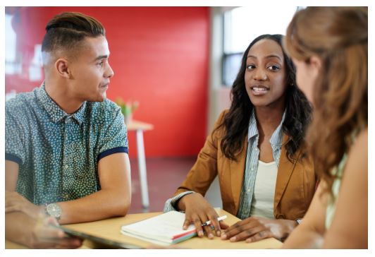 Three people at a table having a conversation.